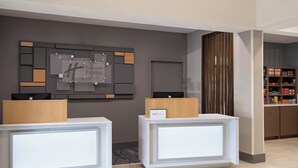 A reception area with two reception desks, a wall-mounted sign, and a storage cabinet. - Holiday Inn Express St. Petersburg North (I-275) by IHG (St. Petersburg)