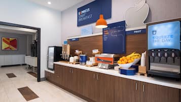 A modern breakfast area with a coffee machine, fruit bowl, and cereal options.