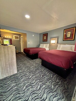 A hotel room with two beds, a desk, and a mirror. - Hometown Inn Athens (Athens)