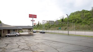 Ein Motel mit der Beschilderung Hometown Inn, einem Parkplatz mit Autos und einer Straße mit Schutzplanke.