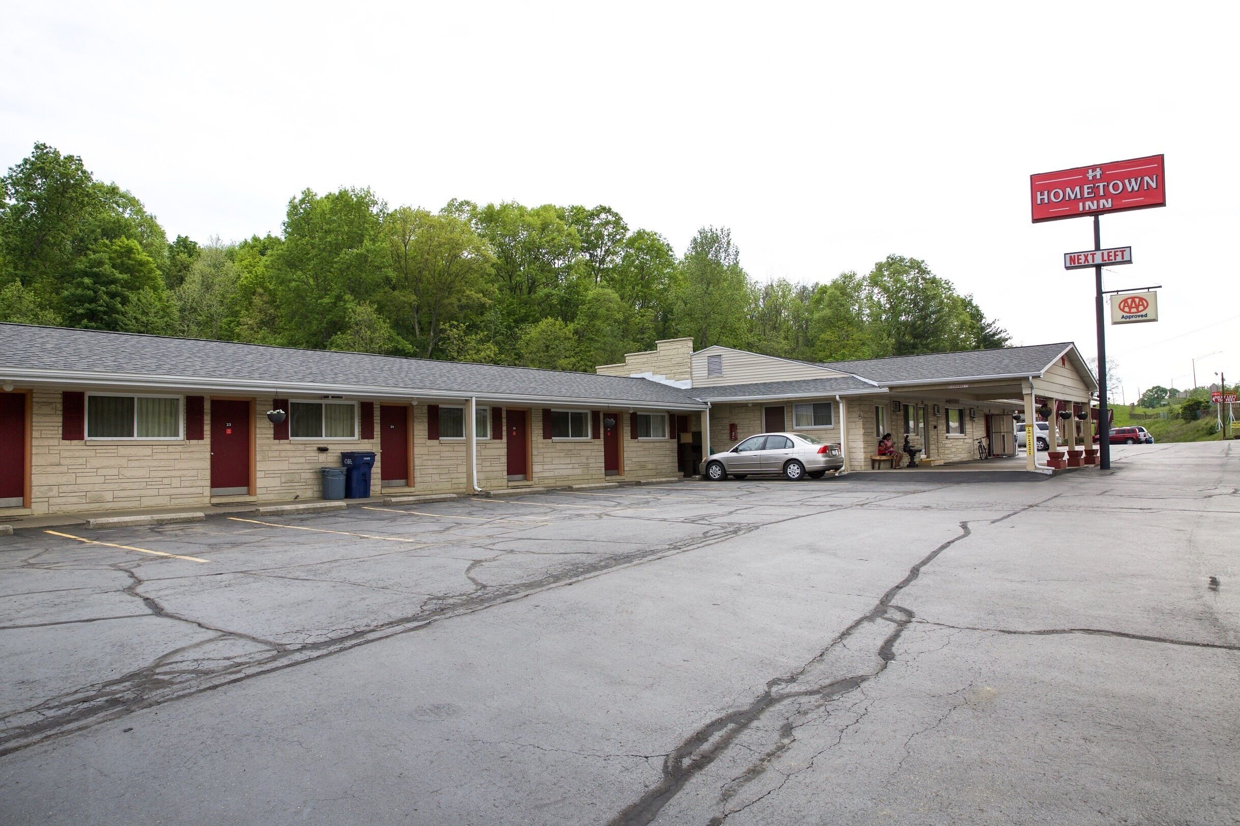 A motel with a parking lot, a sign for Hometown Inn, and a AAA Approved sign.