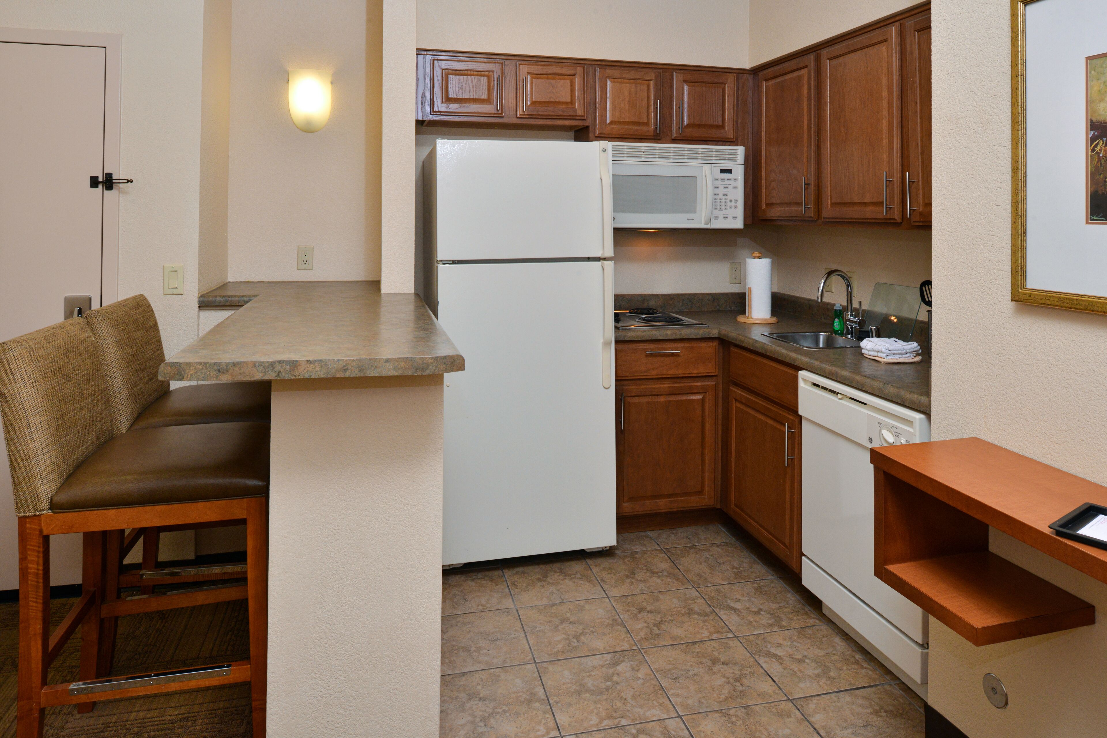A compact kitchen with a refrigerator, microwave, and dishwasher.
