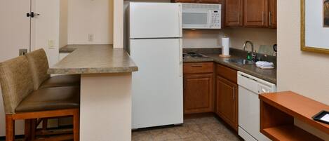 A compact kitchen with a refrigerator, microwave, and dishwasher.