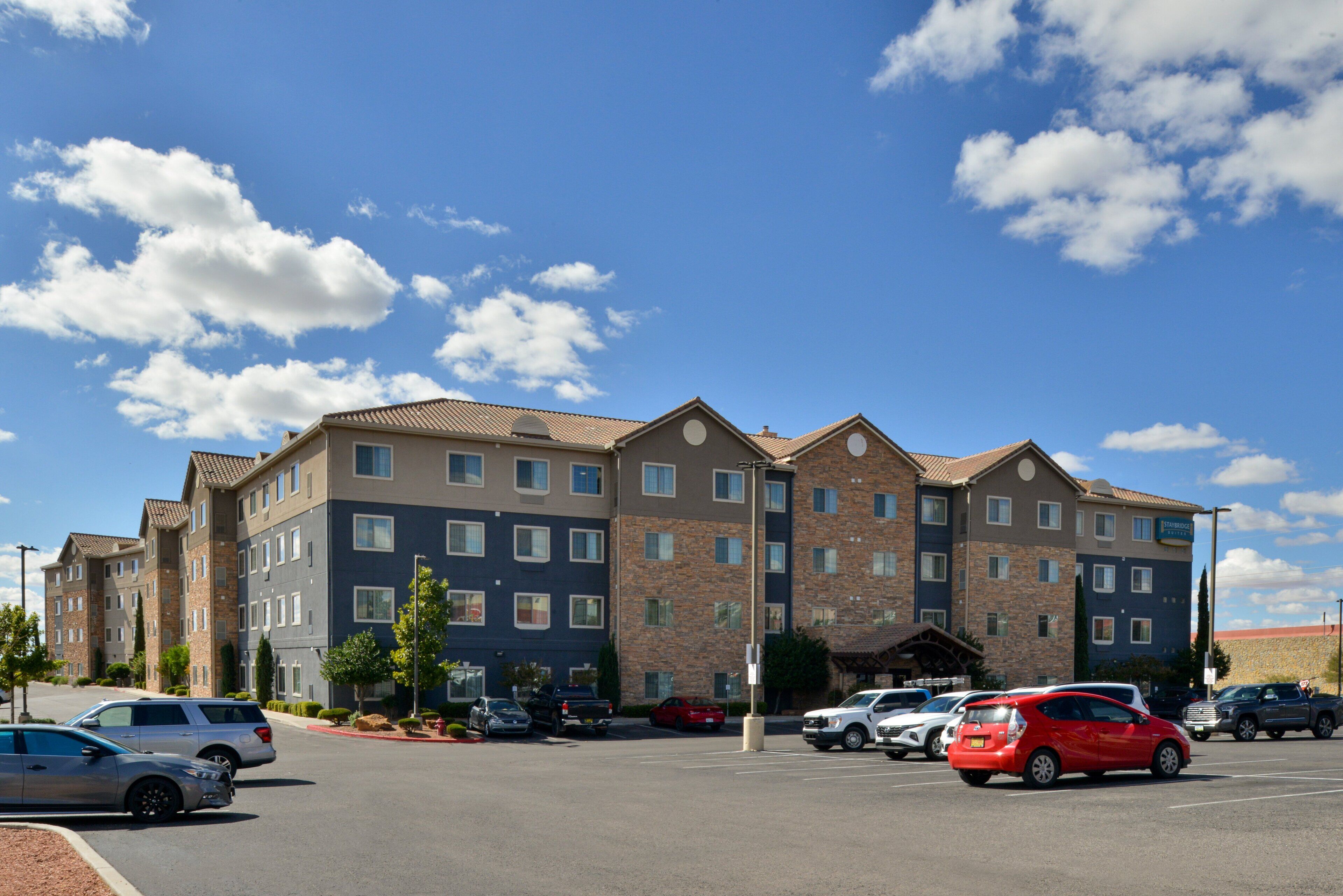 A multi-story hotel with a parking lot in front.