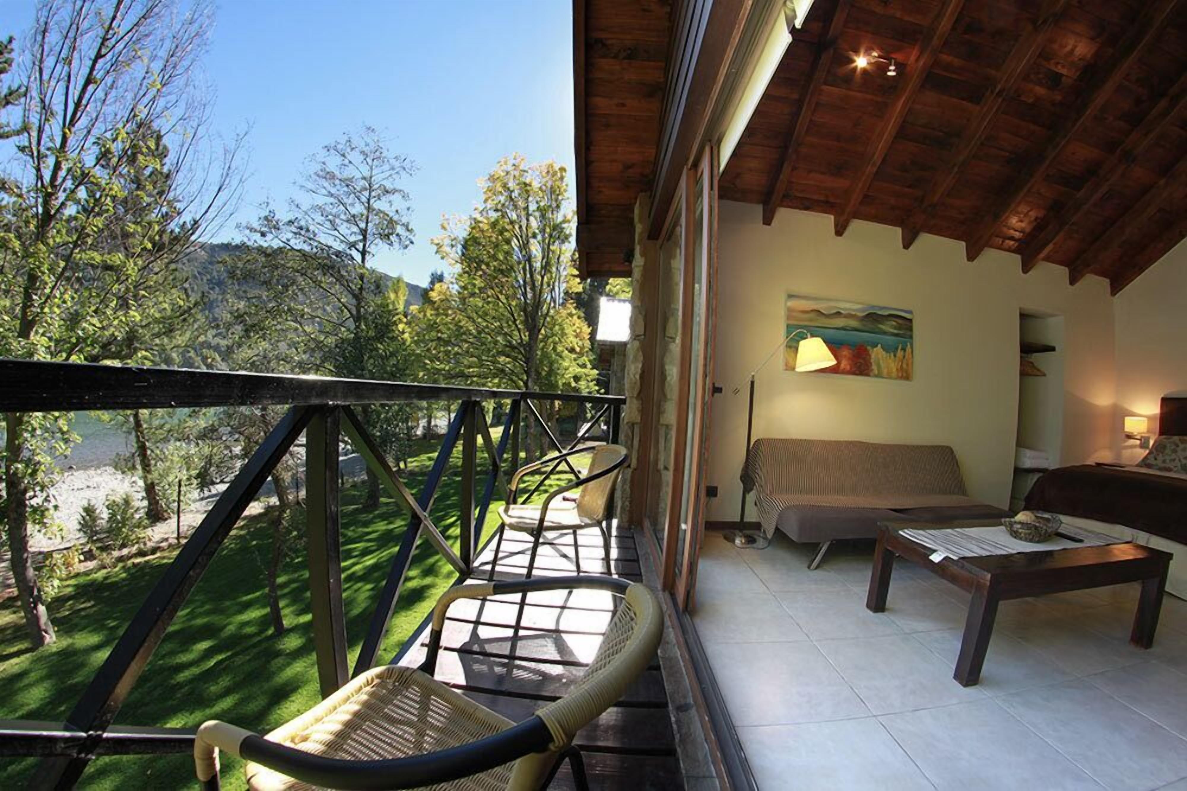 A balcony with wicker chairs, a sofa, and a table.