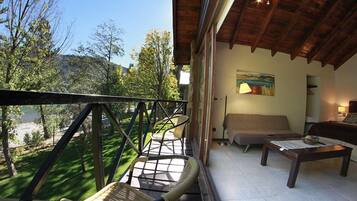 A balcony with wicker chairs, a sofa, and a table.