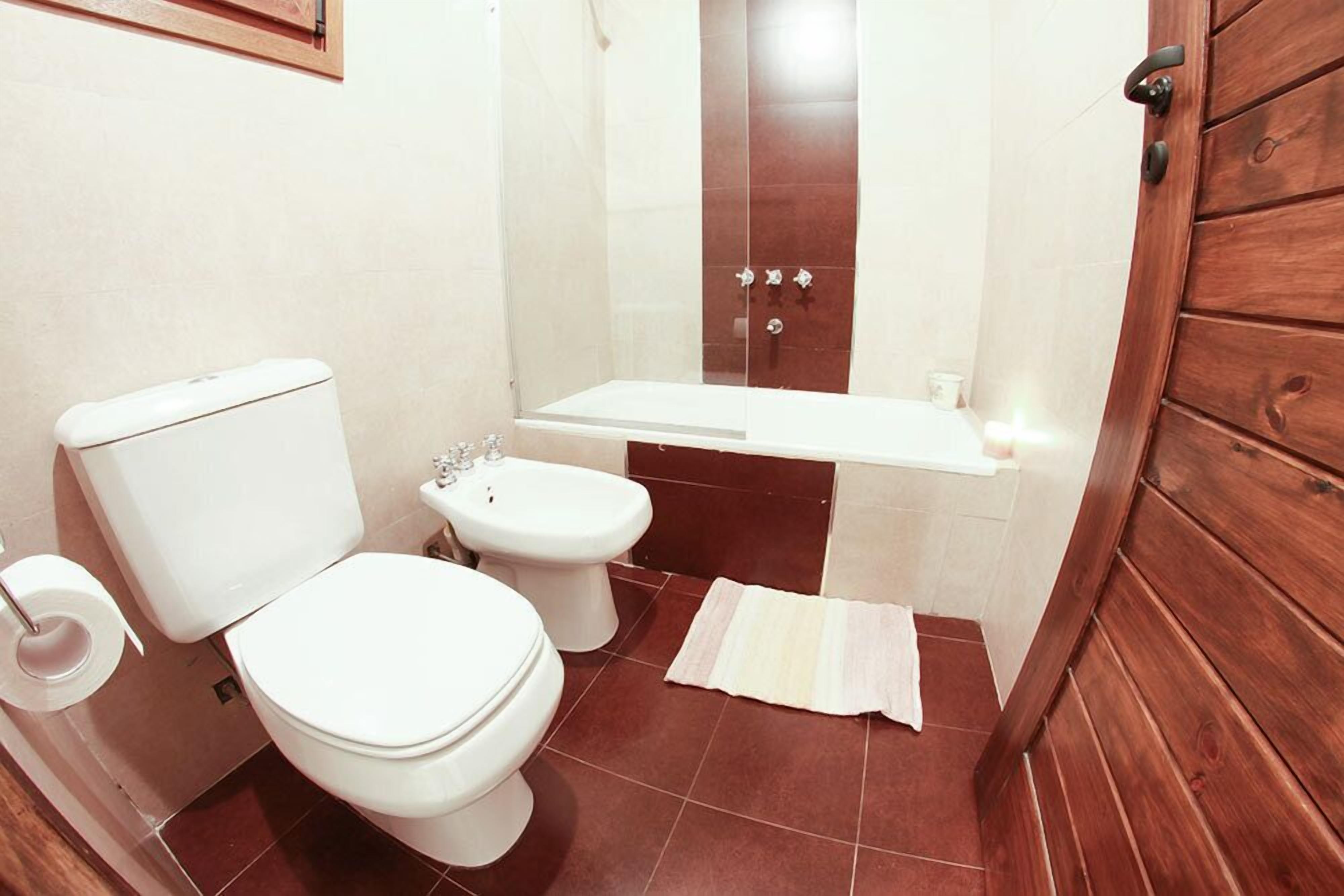 Casa de banho com sanita, bidé e banheira.