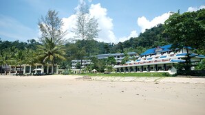 A beachfront hotel with multiple buildings, palm trees, and a clear sky. - Khaolak Sunset Resort - Adults Only (SHA Extra Plus) (Takua Pa)