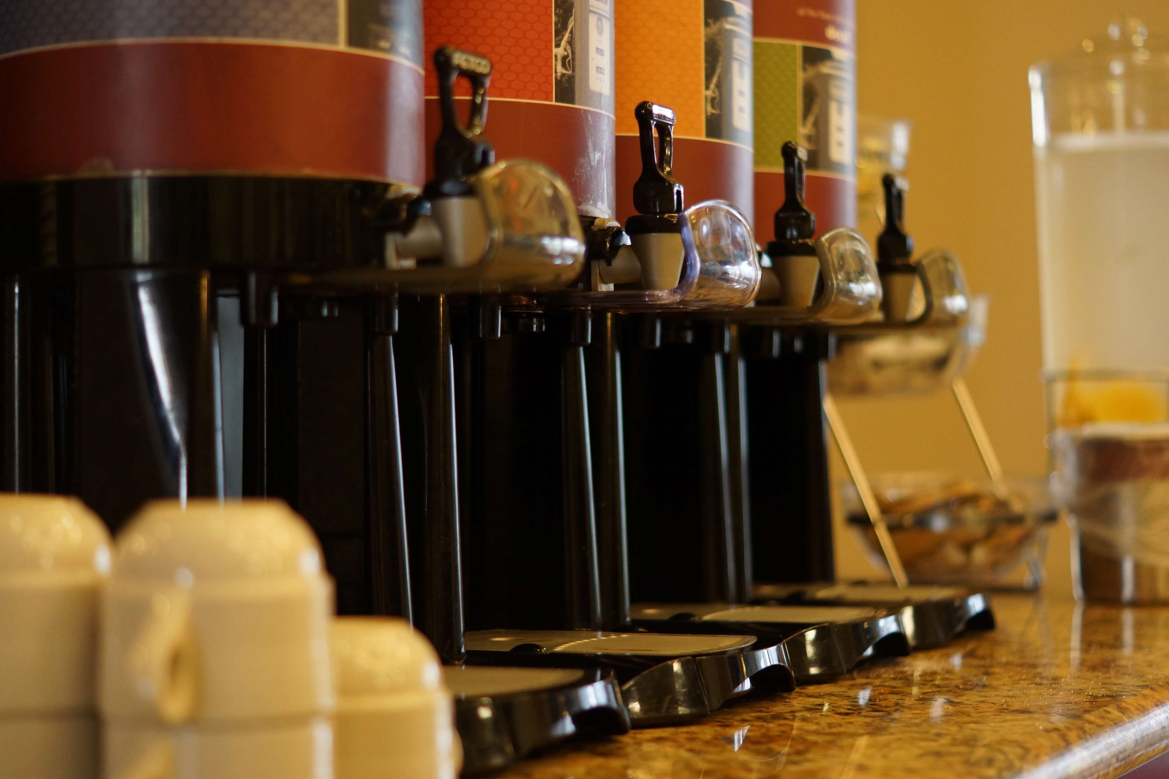 Une machine à café équipée de plusieurs distributeurs et d’un récipient en verre.