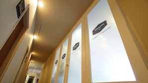 Un pasillo de hotel con puertas de vidrio, cada una identificada con 'Hampton' y 'Tampico Aeropuerto'.