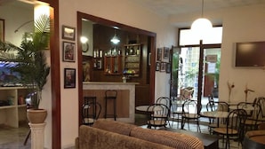 A bar area with a counter, chairs, and a sofa. - Hotel Nova Centro (Jerez de la Frontera)