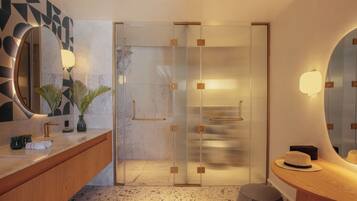 Une salle de bain moderne avec un comptoir en marbre, un grand miroir et une douche dotée de parois en verre.