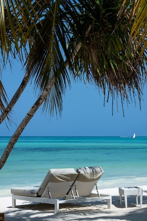 On the beach, white sand, beach cabanas, sun-loungers