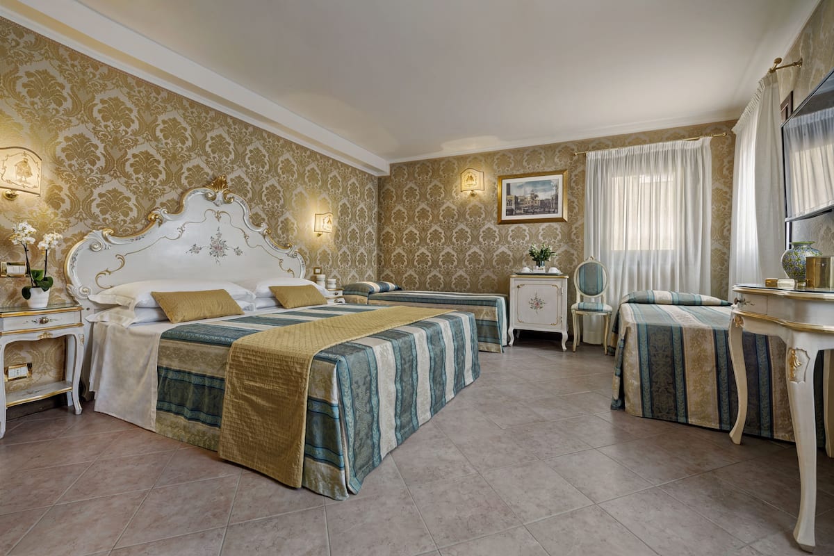 Een hotelkamer met twee bedden, een kaptafel en een bureau.
