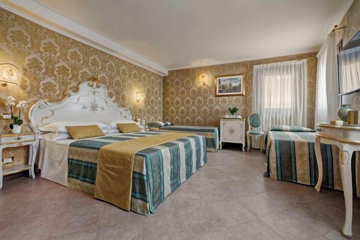 Ett hotellrum med två sängar, en sittgrupp, ett skrivbord och en stol.