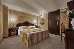 A bedroom with a large bed, a nightstand, a dresser, and a mirror on the wall.