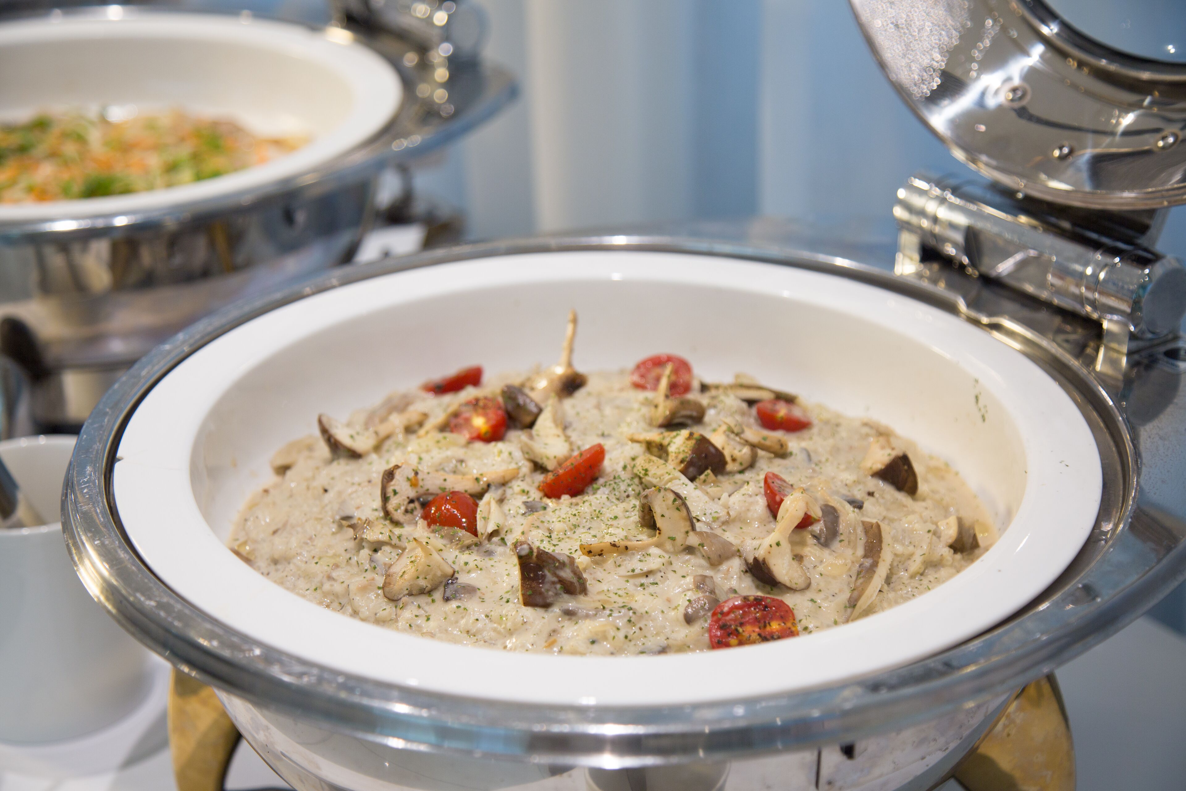 Un tazón de crema de champiñones cremosa, con tomates rojos y hierbas.