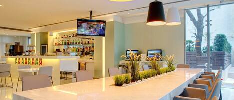 A modern kitchen with a long island, bar area, and large windows.