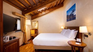 A hotel room with a large bed, a desk with a chair, a television, and a wall-mounted lamp. - Best Western Plus Hotel Le Rondini (San Francesco al Campo)