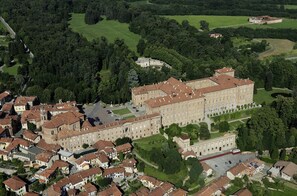 An aerial view of a historic building complex with multiple buildings, surrounded by lush greenery and a golf course.