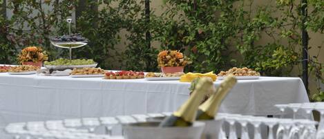 Una mesa de buffet con diversos alimentos y una botella de champán.