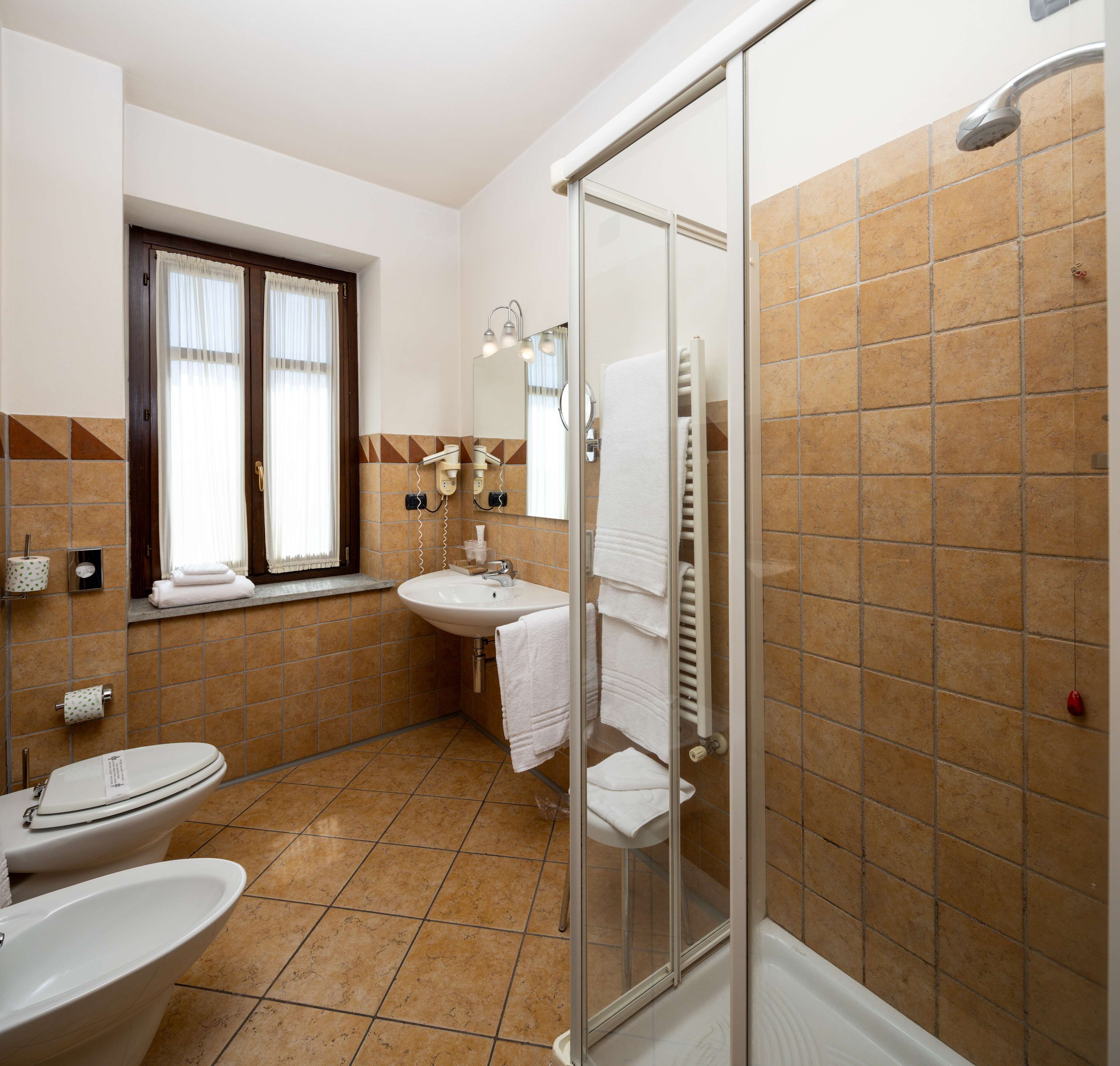 Un baño con inodoro, lavabo y ducha.