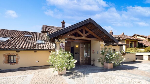 A traditional building with a tiled roof, a wooden entrance, and potted plants. - Best Western Plus Hotel Le Rondini (San Francesco al Campo)