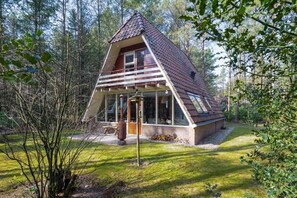 A triangular wooden cabin with a glass balcony, surrounded by a forest. - Veluwe Hotel Stakenberg (Elspeet)