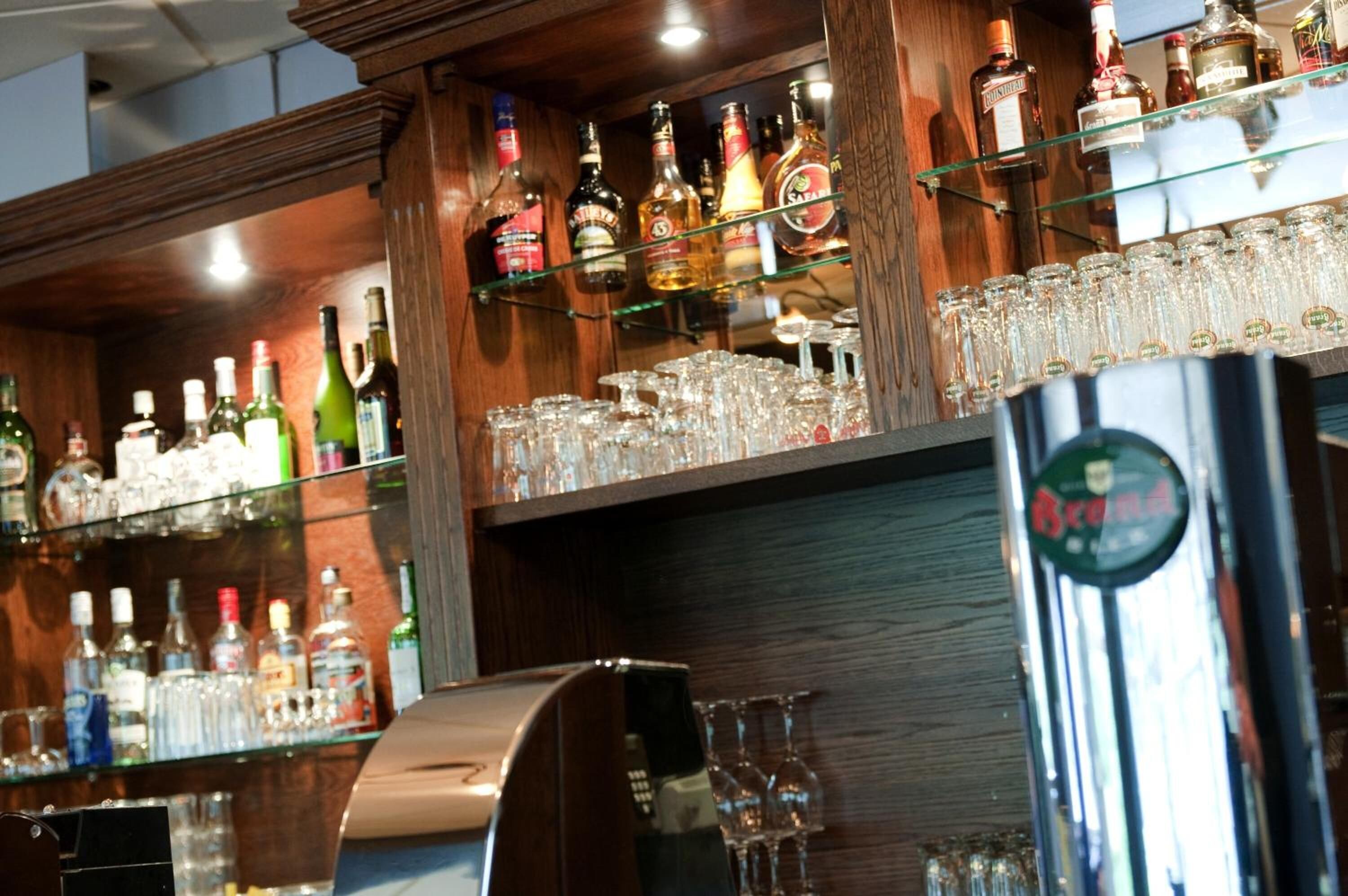 A bar area with shelves of liquor bottles and glasses.