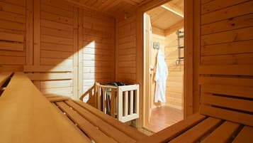 Una cabaña de madera con un banco, una mesita y una puerta que da a un cuarto con ducha.