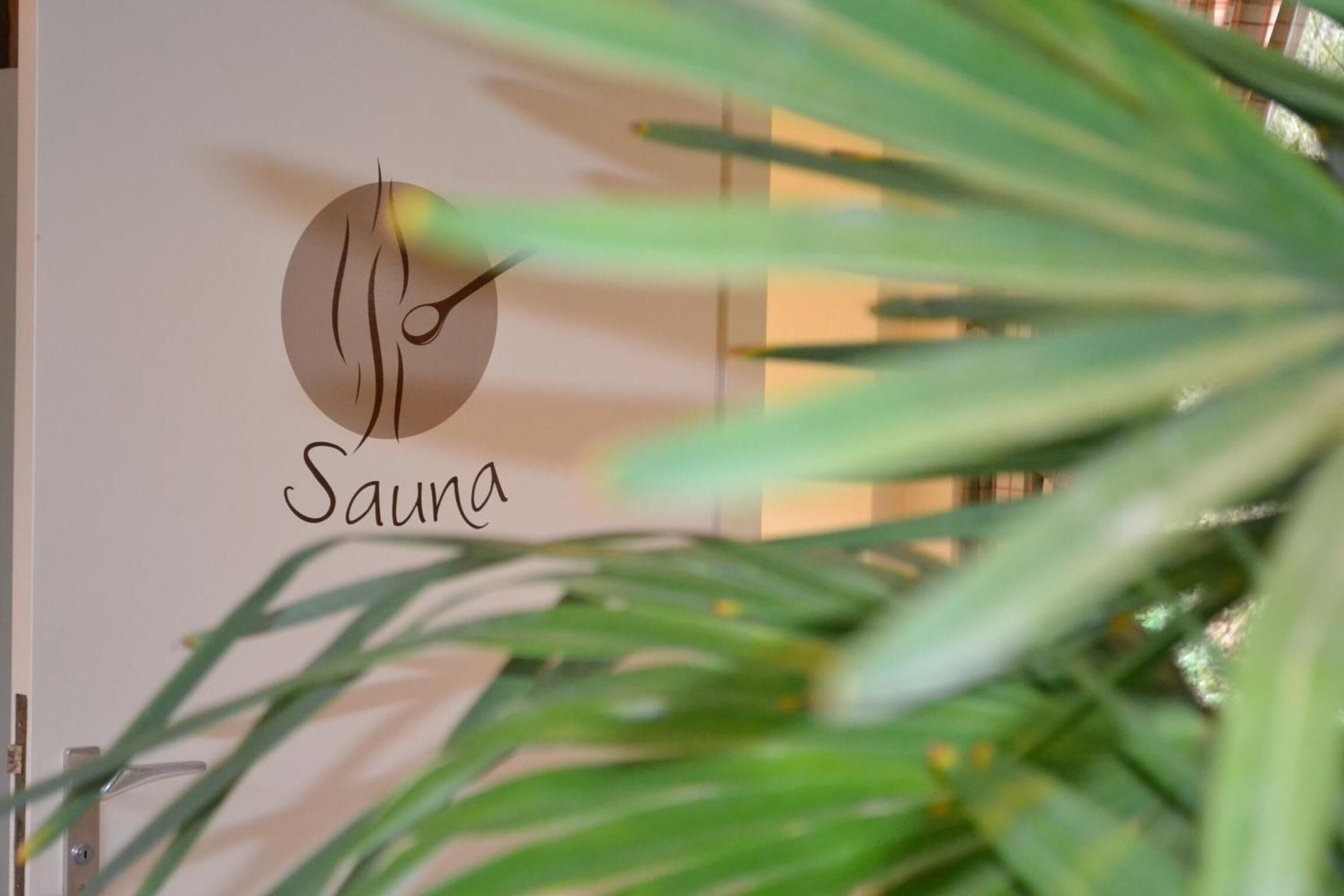 Een logo met het woord 'Sauna' op een muur.