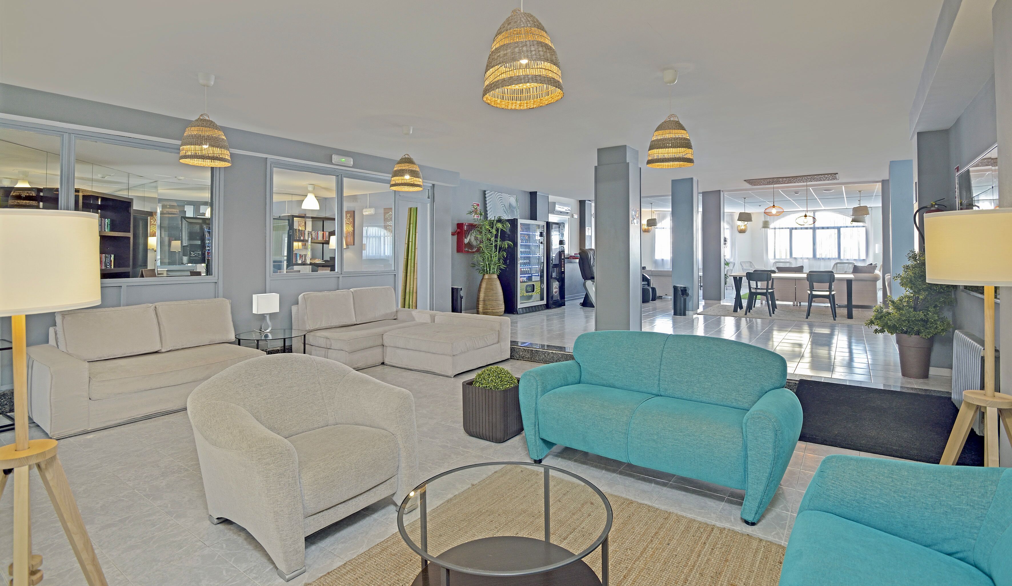 En rymlig entréhall med en sittgrupp, en automattankstation och en matplats i bakgrunden.