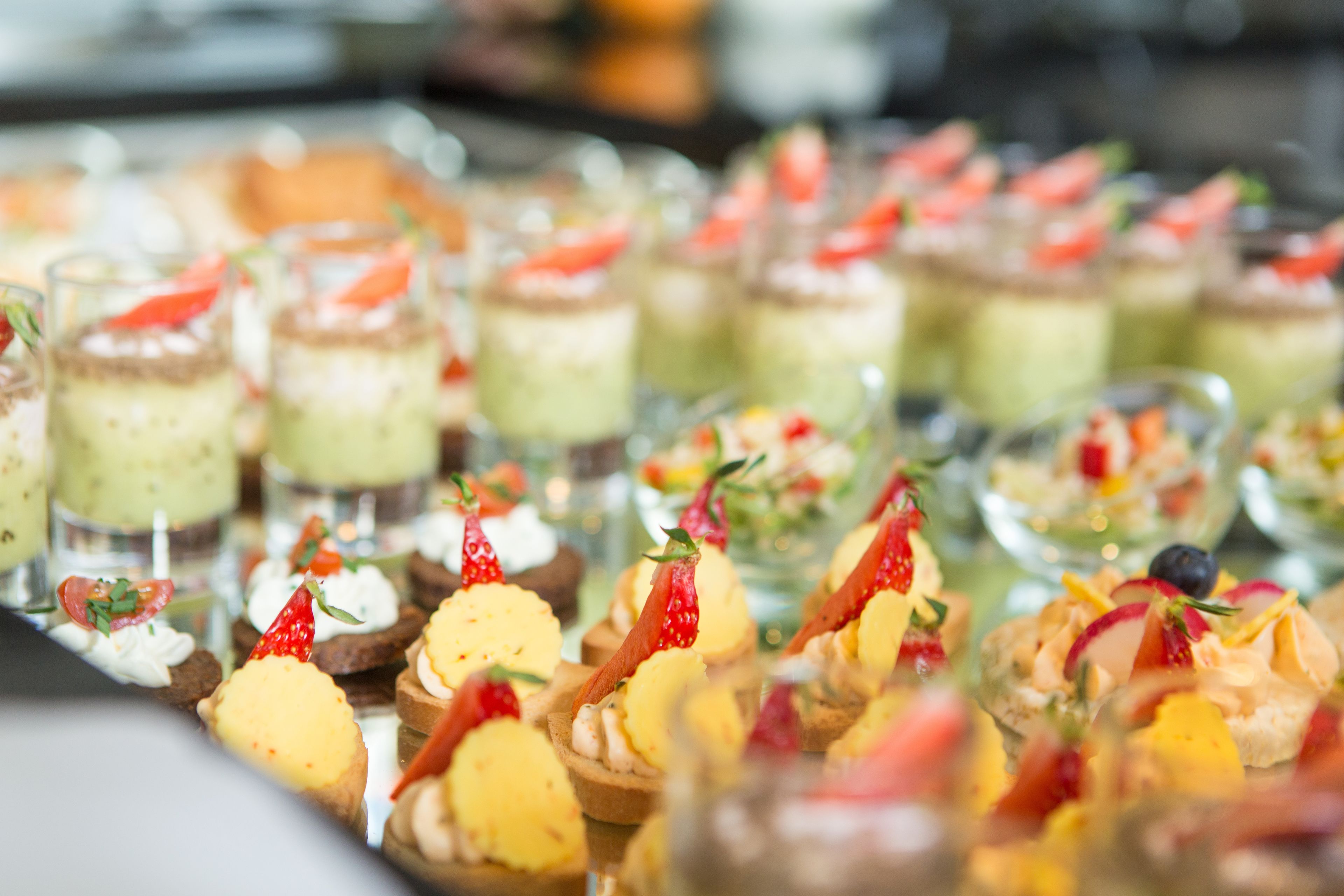 Variedad de postres dispuestos en una bandeja, incluyendo pequeños pasteles y dulces con frutas.
