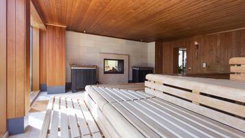 A modern interior with wooden benches, a fireplace, and a stone wall.