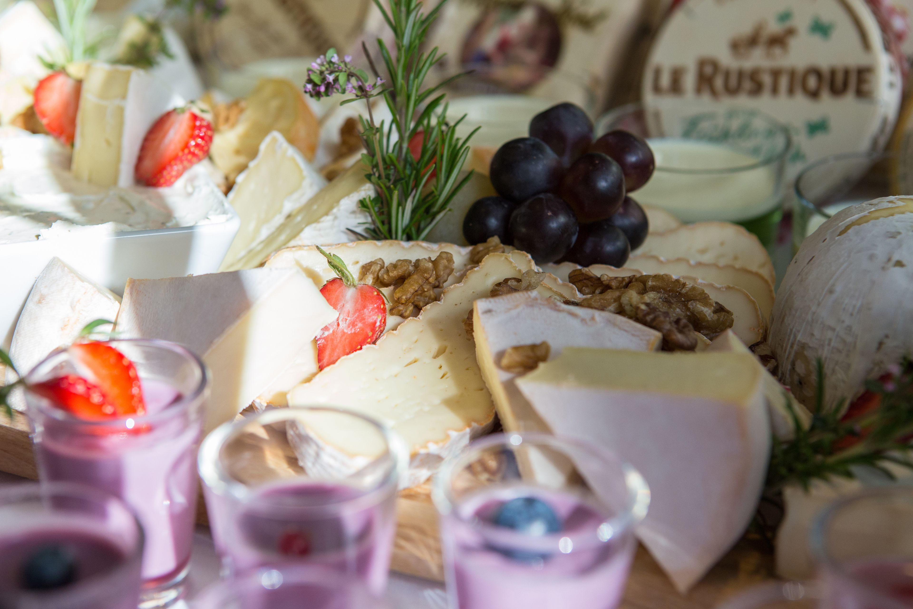 Una selección de quesos, frutas y frutos secos sobre una tabla de madera.