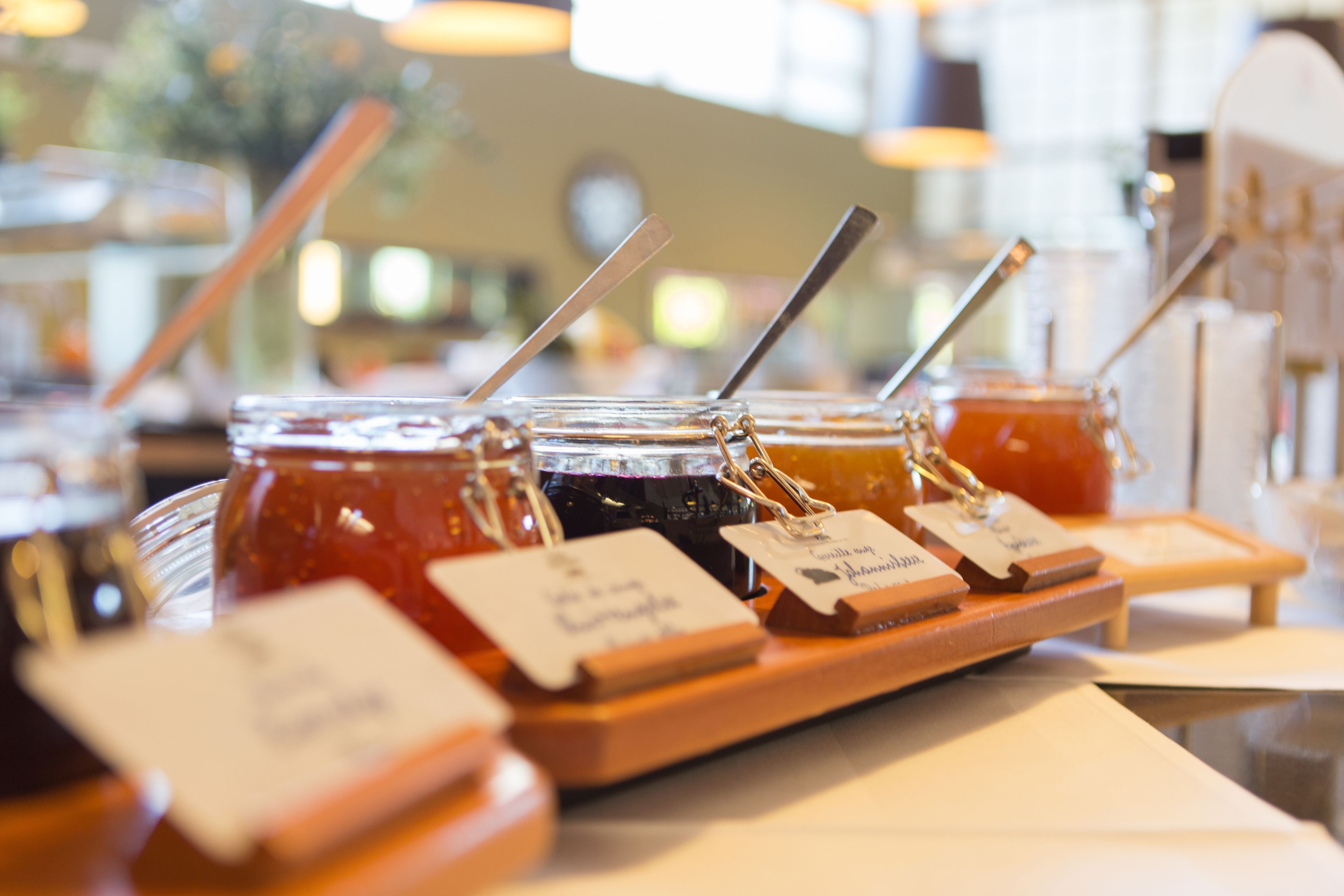 A display of various jams with labels and straws in a store.