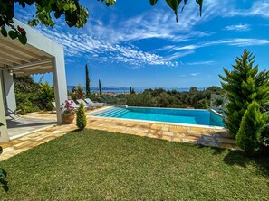 A swimming pool with a view of the sea, surrounded by a well-maintained lawn and potted plants. - La Riviera Barbati (Corfu)