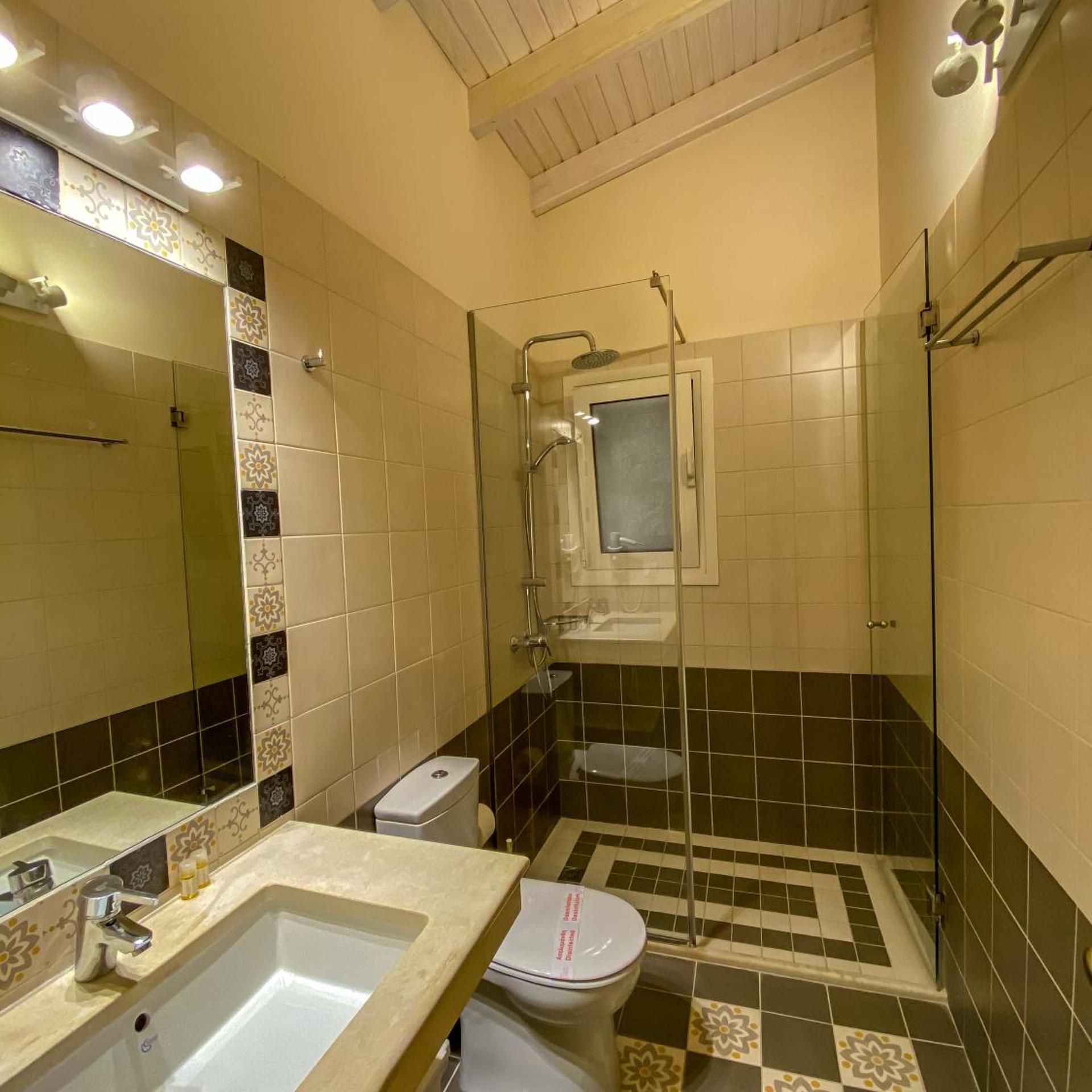 Un bagno con doccia, WC e lavandino.