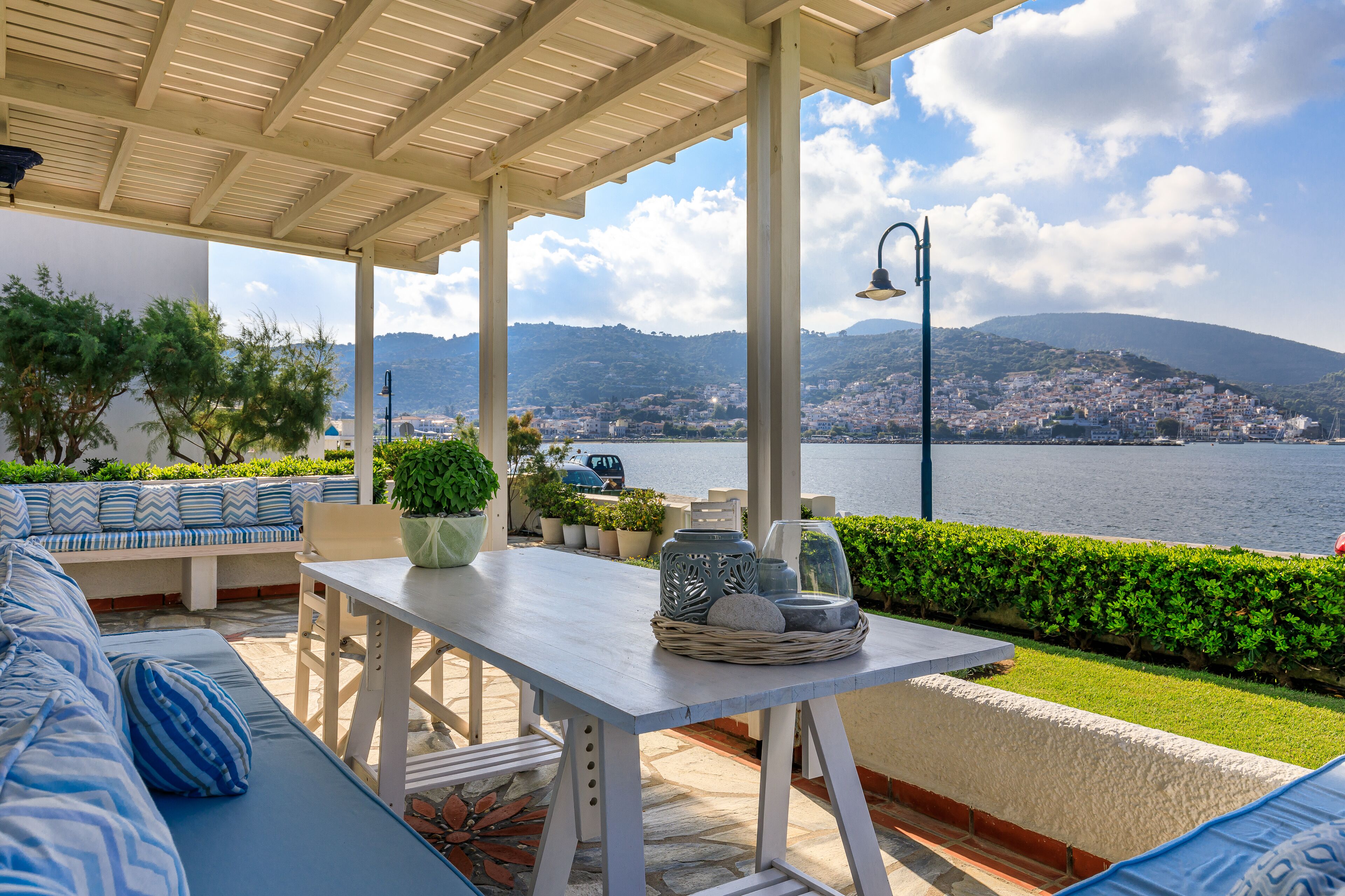 Zona de estar al aire libre con vistas al mar y colinas.