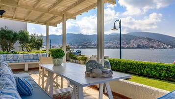 Zona de estar al aire libre con vistas al mar y colinas.