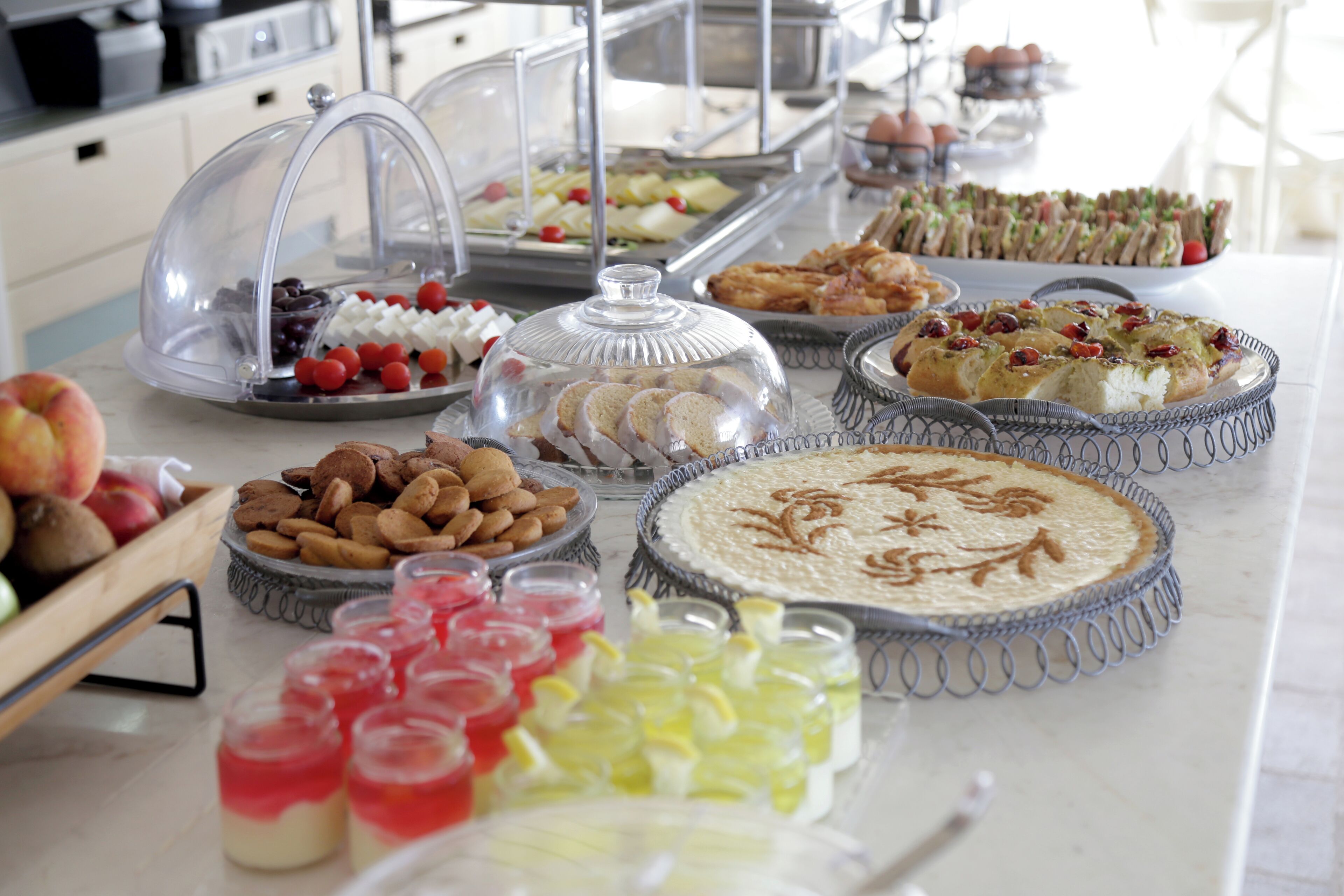A buffet with various food items including pies, pastries, and desserts.