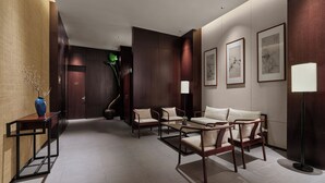 A modern lobby with a reception desk, seating area, and artwork on the walls. - Poly Plaza Hotel (Beijing)