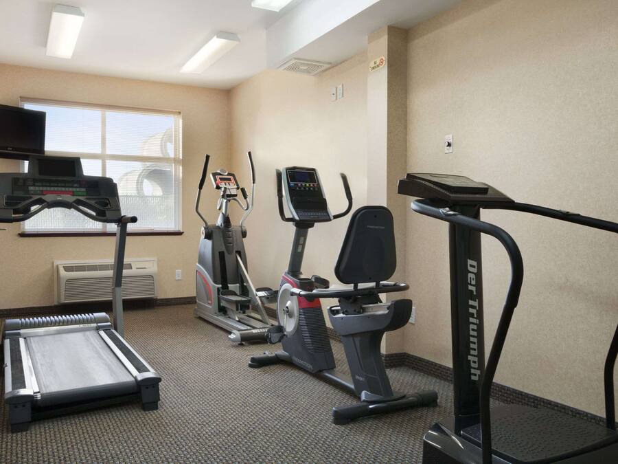 A fitness room with treadmills, elliptical machines, and a stationary bike.