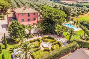 A large villa with a swimming pool, surrounded by well-maintained gardens and palm trees. - Relais Pian di Vico- Guest House (Tuscania)