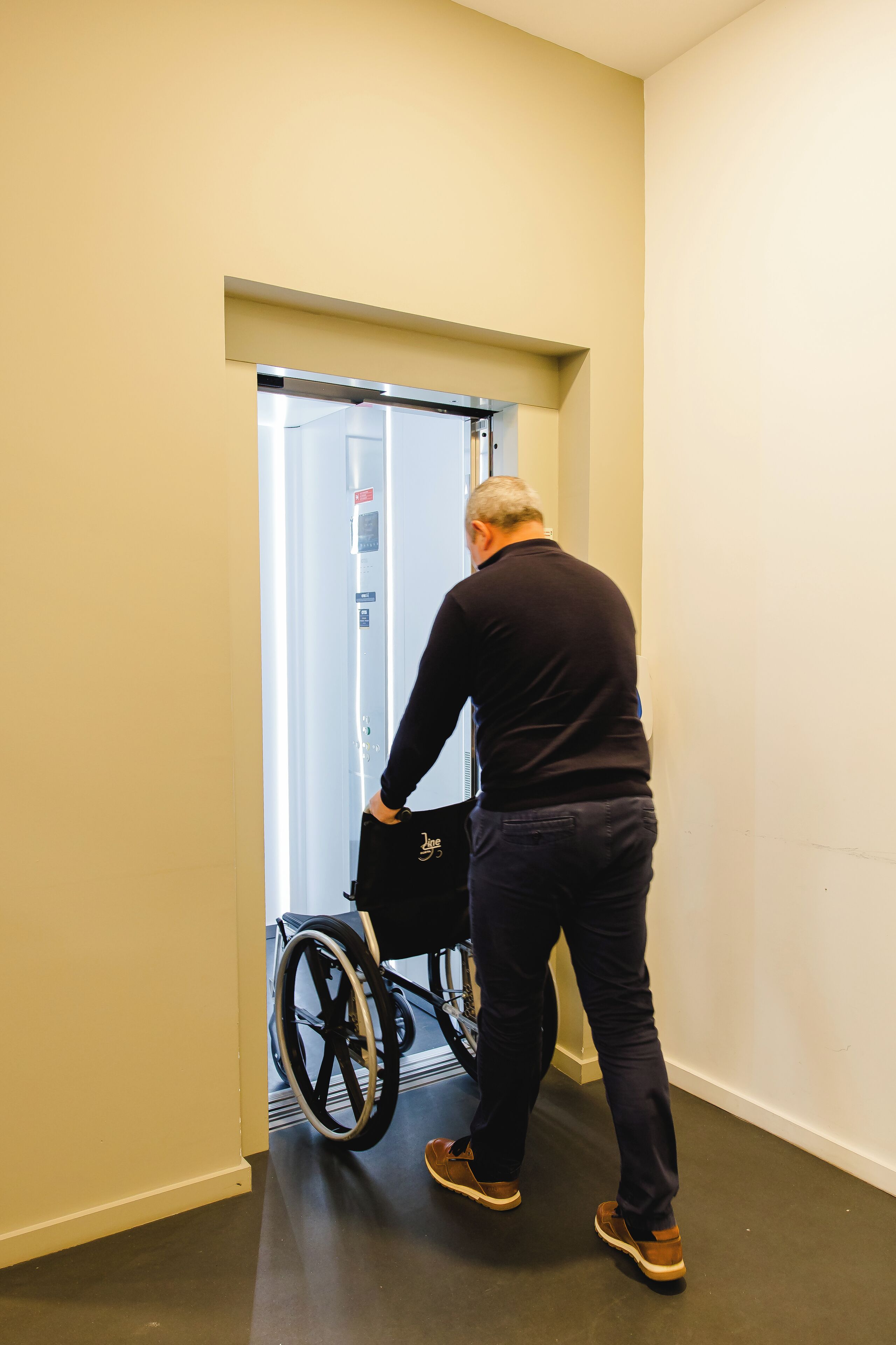 A man in a wheelchair entering a lift.