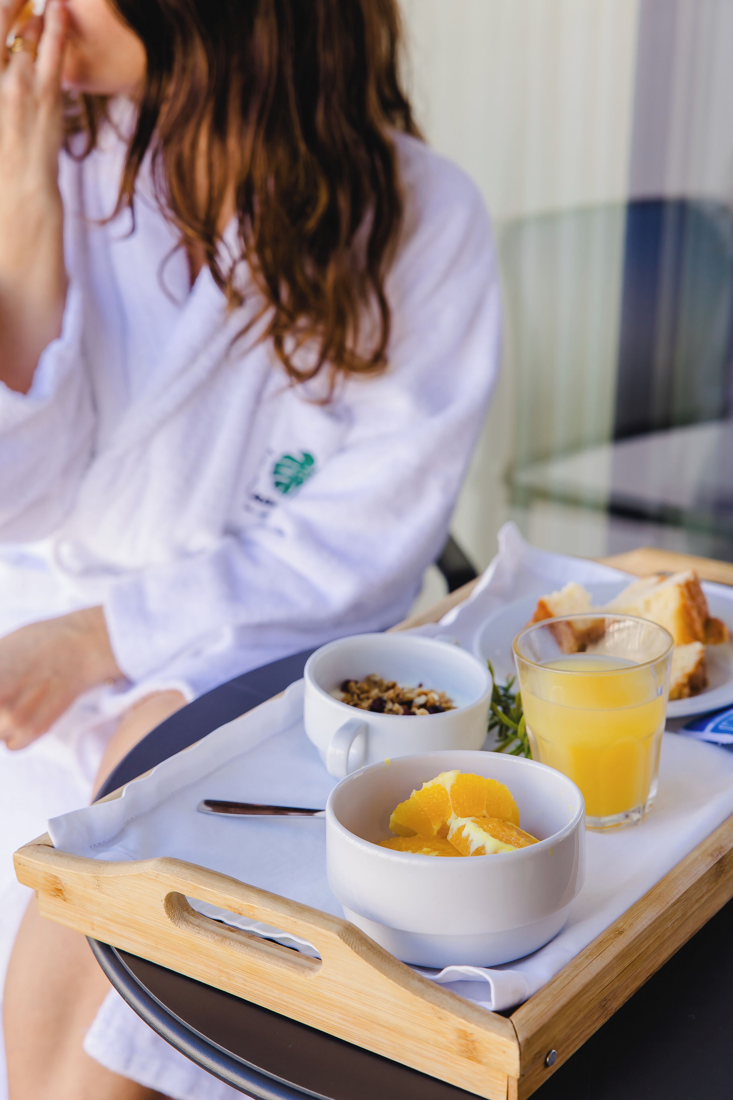 A tray with breakfast items including a bowl of cereal, a glass of orange juice, and a plate of toast.