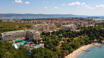 A hotel with multiple buildings, a swimming pool, and a beach.
