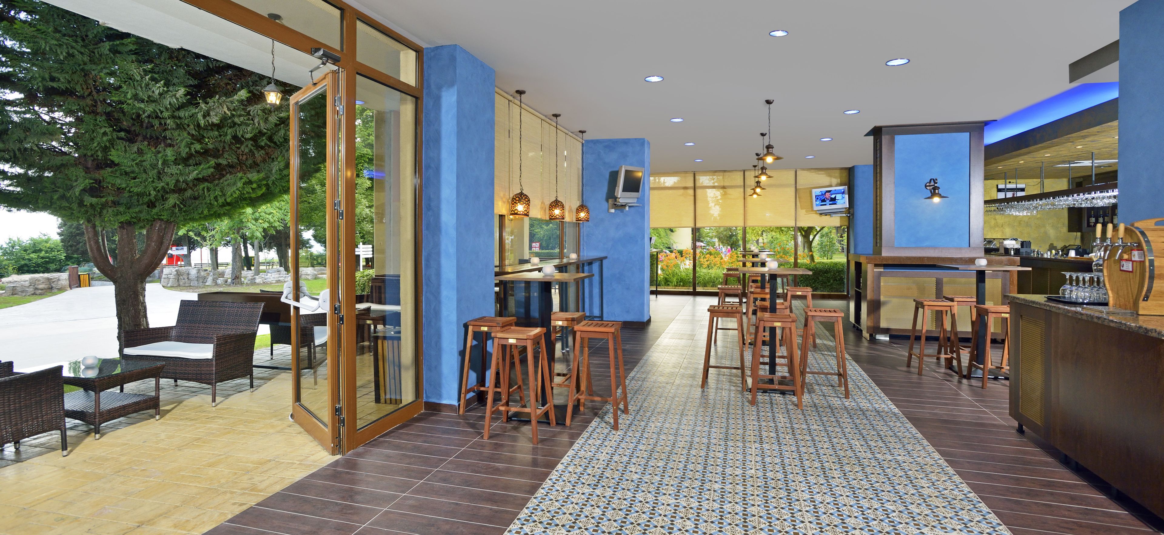 A modern bar area with seating and a view of the outdoors.