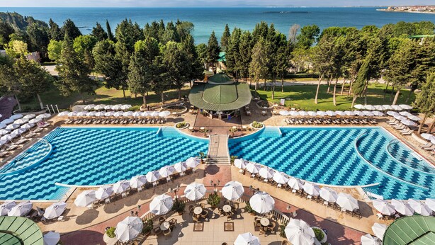 A resort with two large swimming pools, outdoor seating areas, and a view of the sea. - Sol Nessebar Palace - All Inclusive (Nessebar)