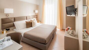 Een moderne hotelkamer met een groot bed, nachtkastjes, een flatscreen televisie en een bureau met stoel.